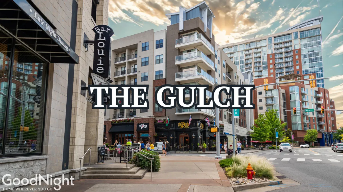 An energetic street view of The Gulch neighborhood, featuring Bar Louie, The Gulch sign, modern apartment buildings, and active street life. The area is bustling with dining, shopping, and social opportunities—capturing the spirit of Nashville's urban core.